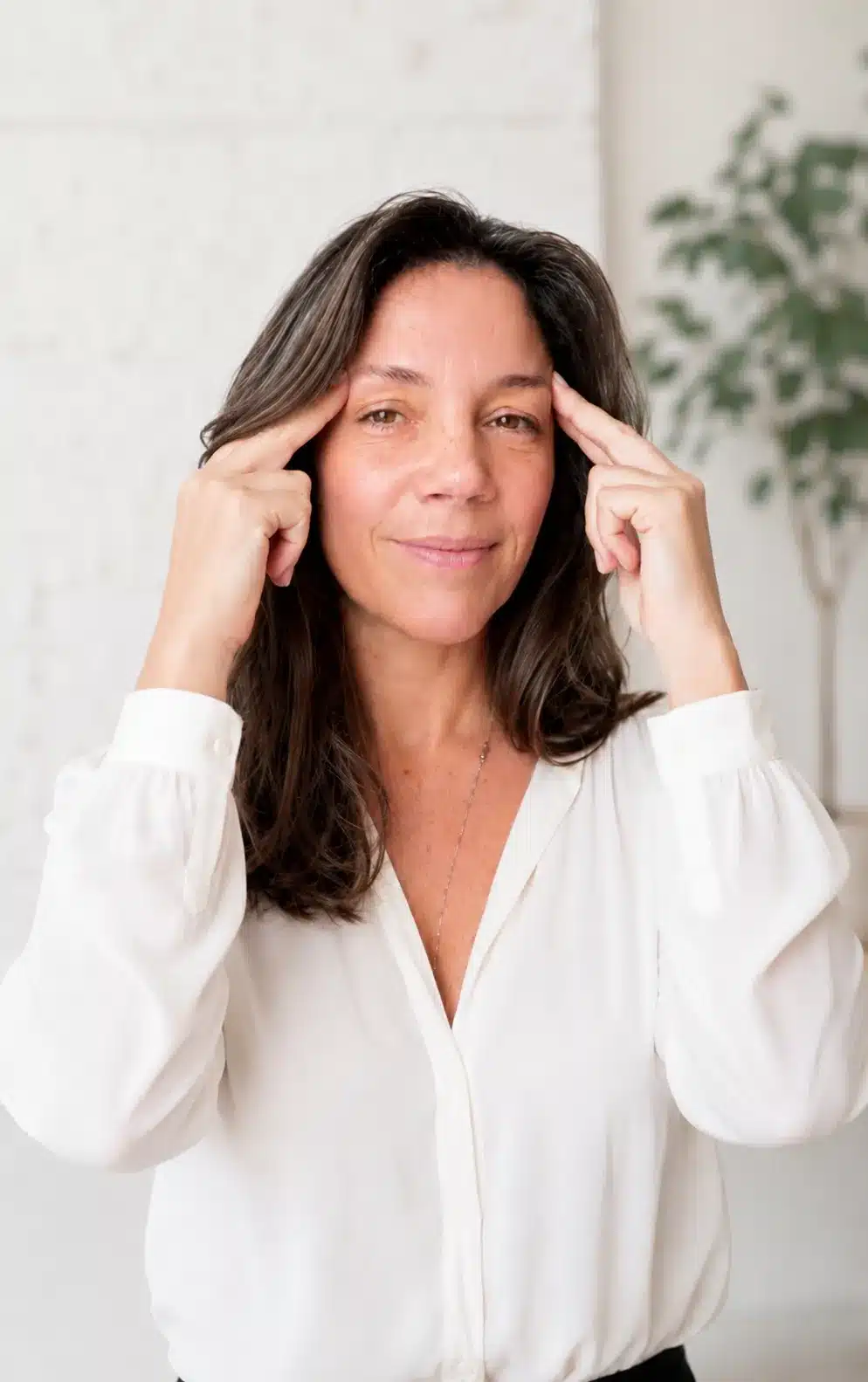 Virginie Boyer Praticienne EFT, debout en chemiser blanc avec les doigts sur les tempes, point d'EFT